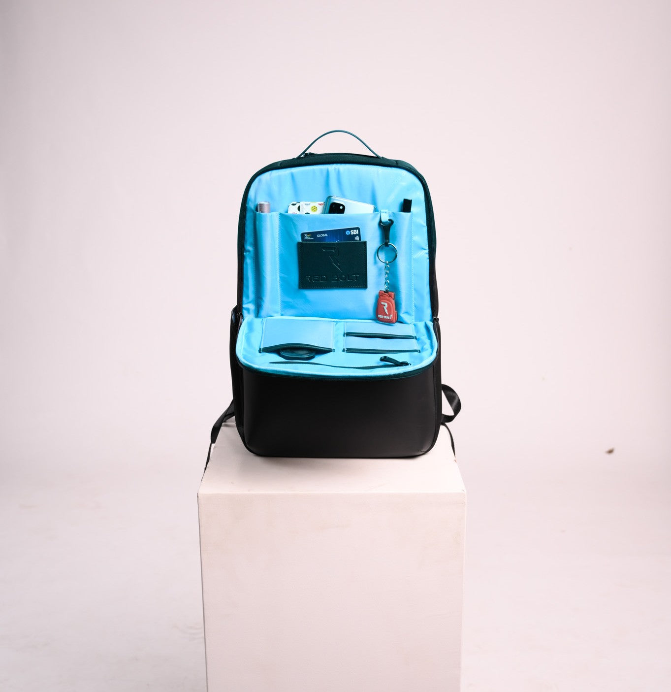 Black backpack with blue interior on a white pedestal against a light gray background